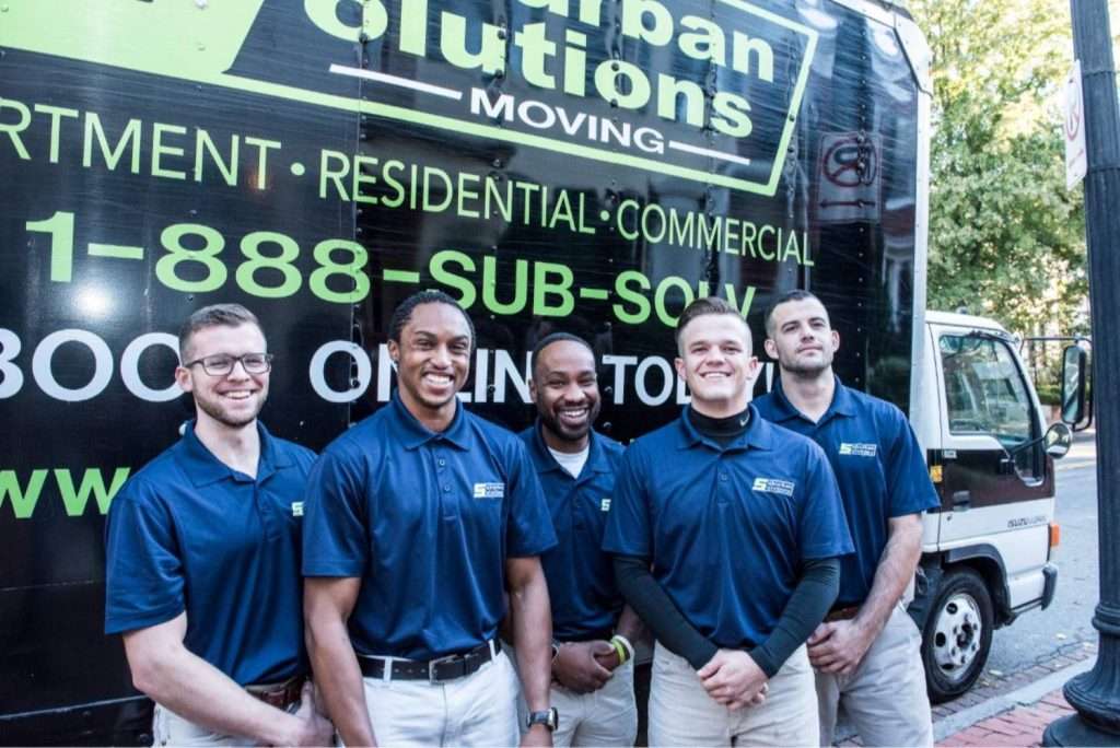 Five furniture movers from a Philadelphia office moving company posing a moving truck